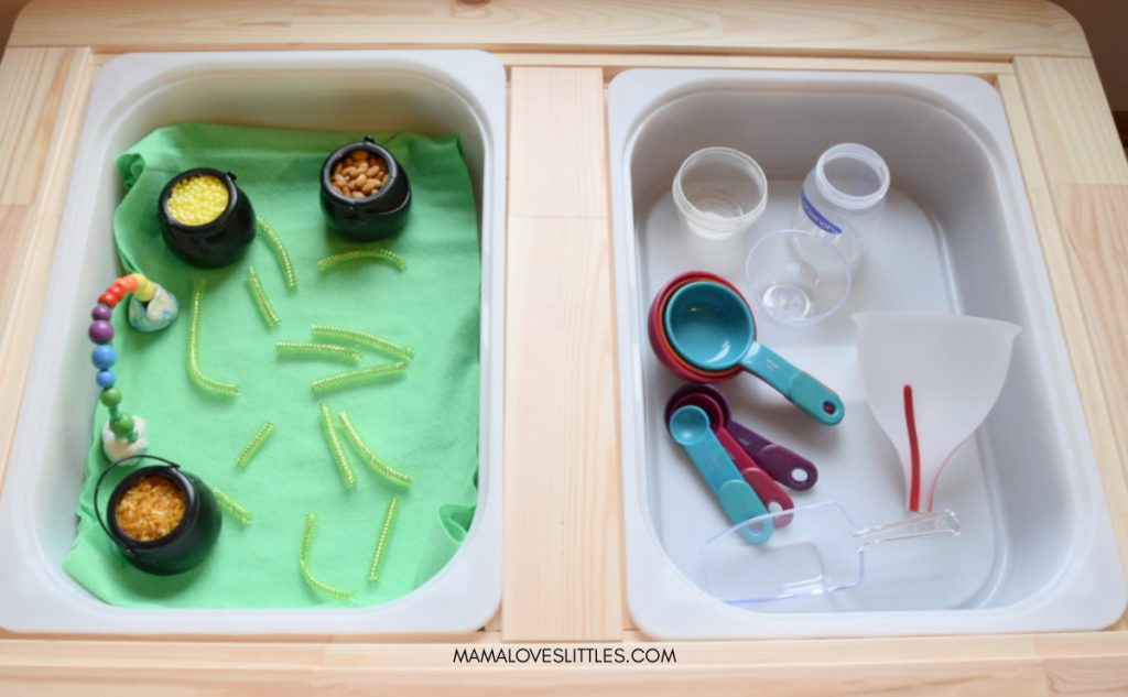Sensory table with two bins. One with materials for Pots of Gold sensory play for St. Patrick's Day. One with tools to use for scooping and filling. 