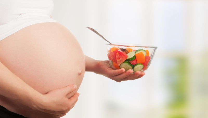 Pregnant woman holding a salad