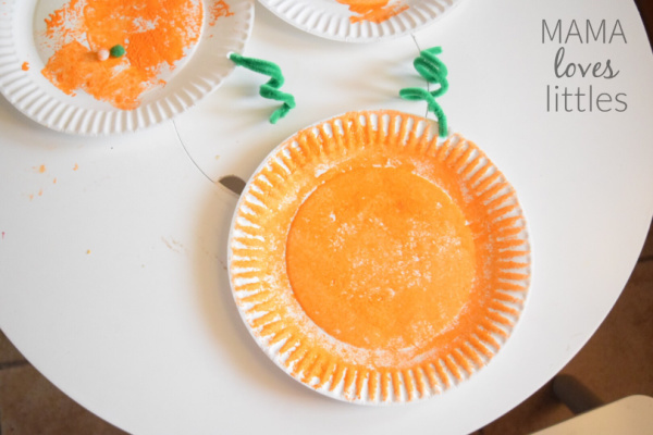 Paper plate pained with orange paint for pumpkin craft
