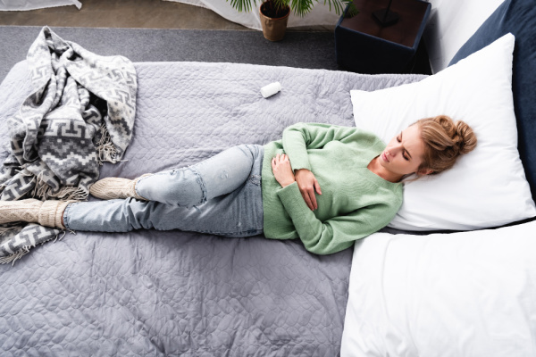 Woman lying in bed with morning sickness