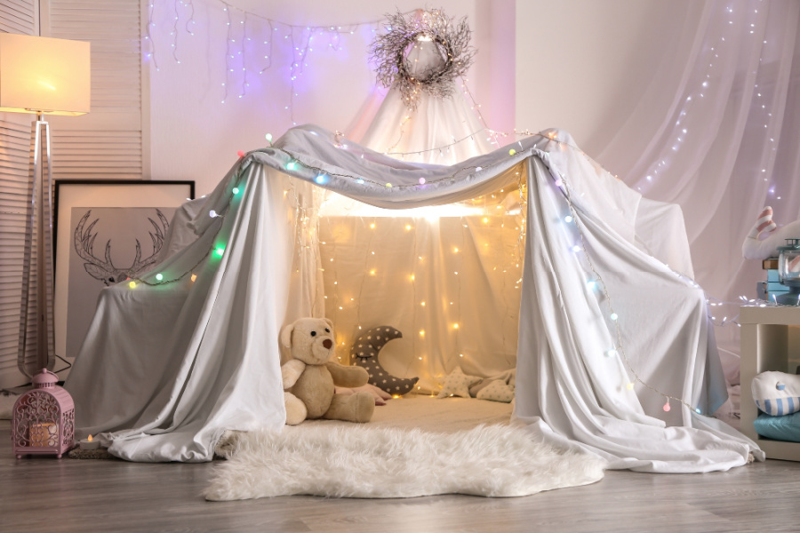 Fort made of sheets to play or sleep in with colorful lights that looks magical